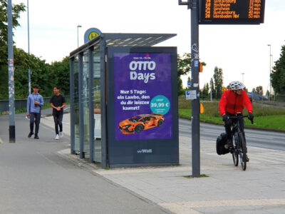 Bushaltestelle am Bahnhof Kastel, ein Radfahrer fährt am Wartehäuschen vorbei.